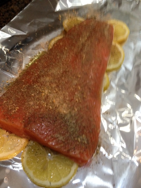 Place salmon on the lemon and coat with lemon-infused olive oil and spices.